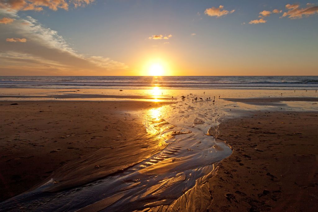 a sunset over a sandy beach