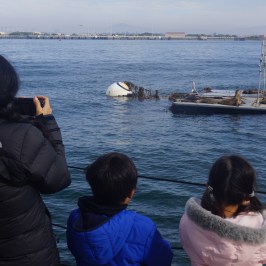 a group of people in a small boat in a body of water