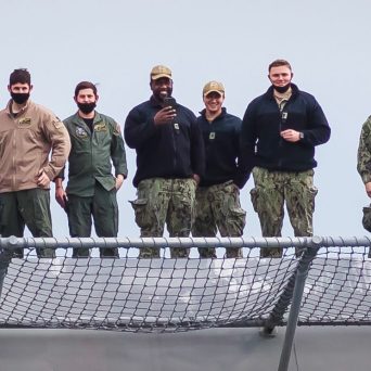 a group of people posing for a wire fence