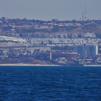 a large body of water with a city in the background