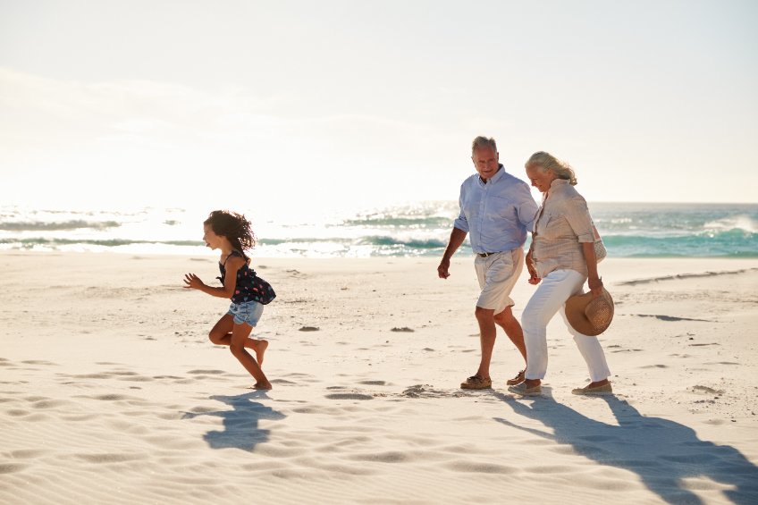 a couple of people that are standing in the sand on a beach