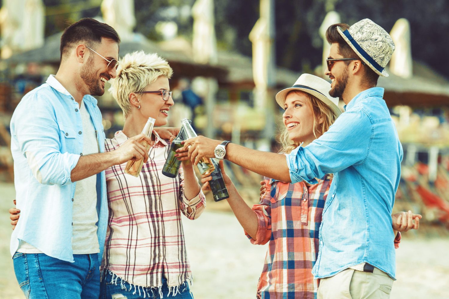 group a friends on a beach together with drinks