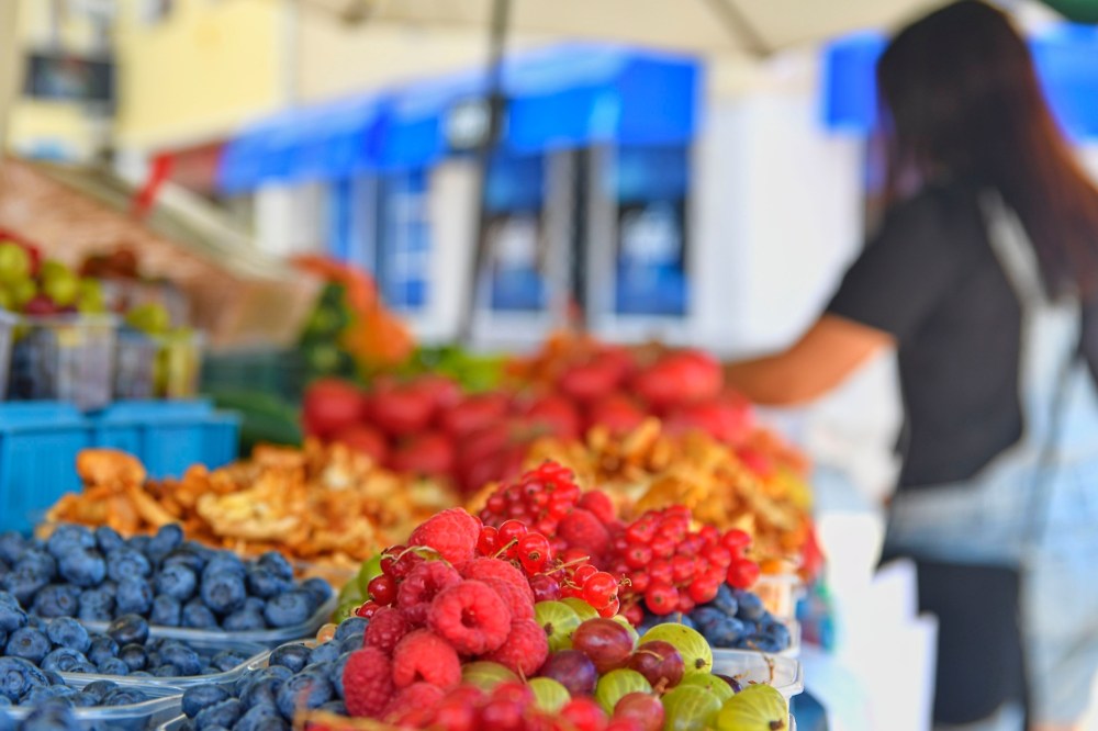 a group of people sitting at a fruit stand