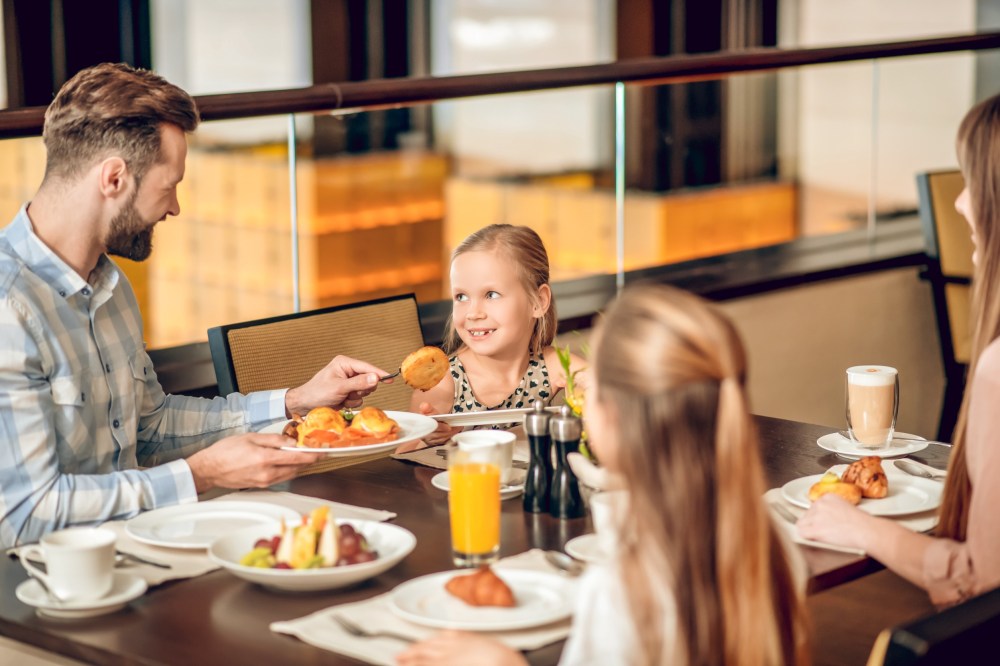 a group of people sitting at a table eating food