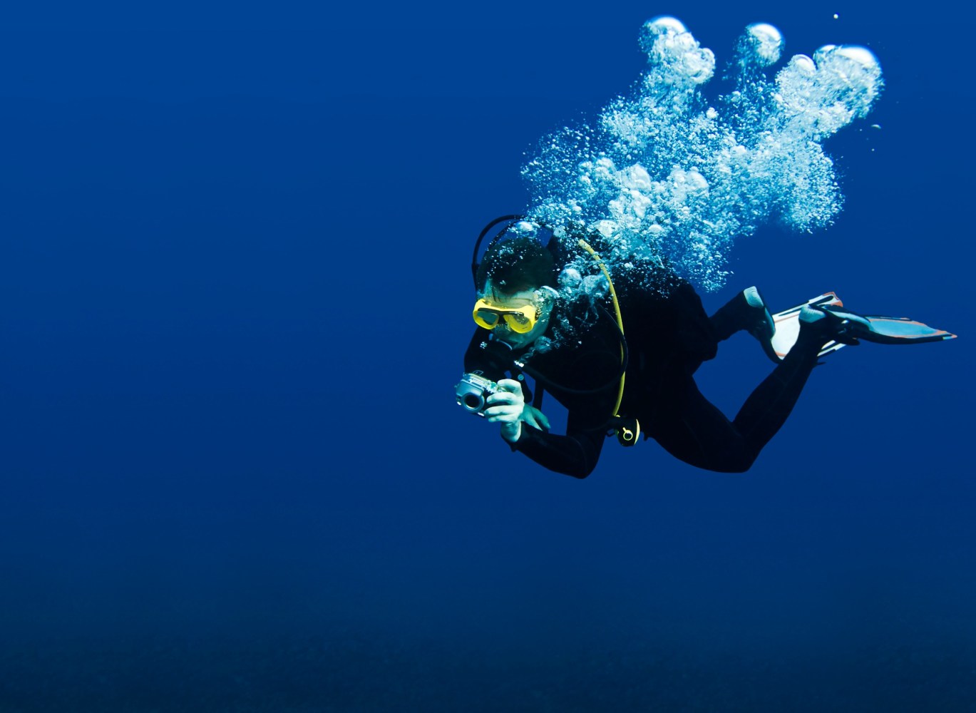 a man scuba diving in clear blue water