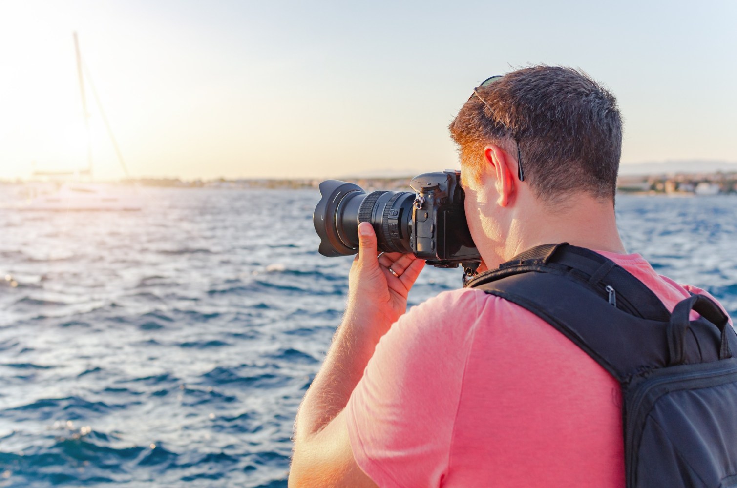 a man photographing next to a body of water