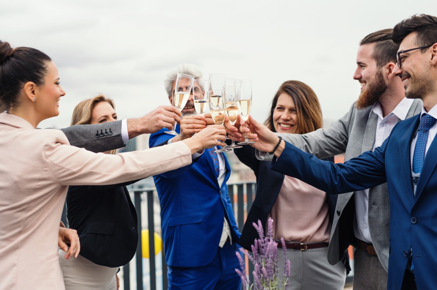 a group of people cheers over champagne on a boat