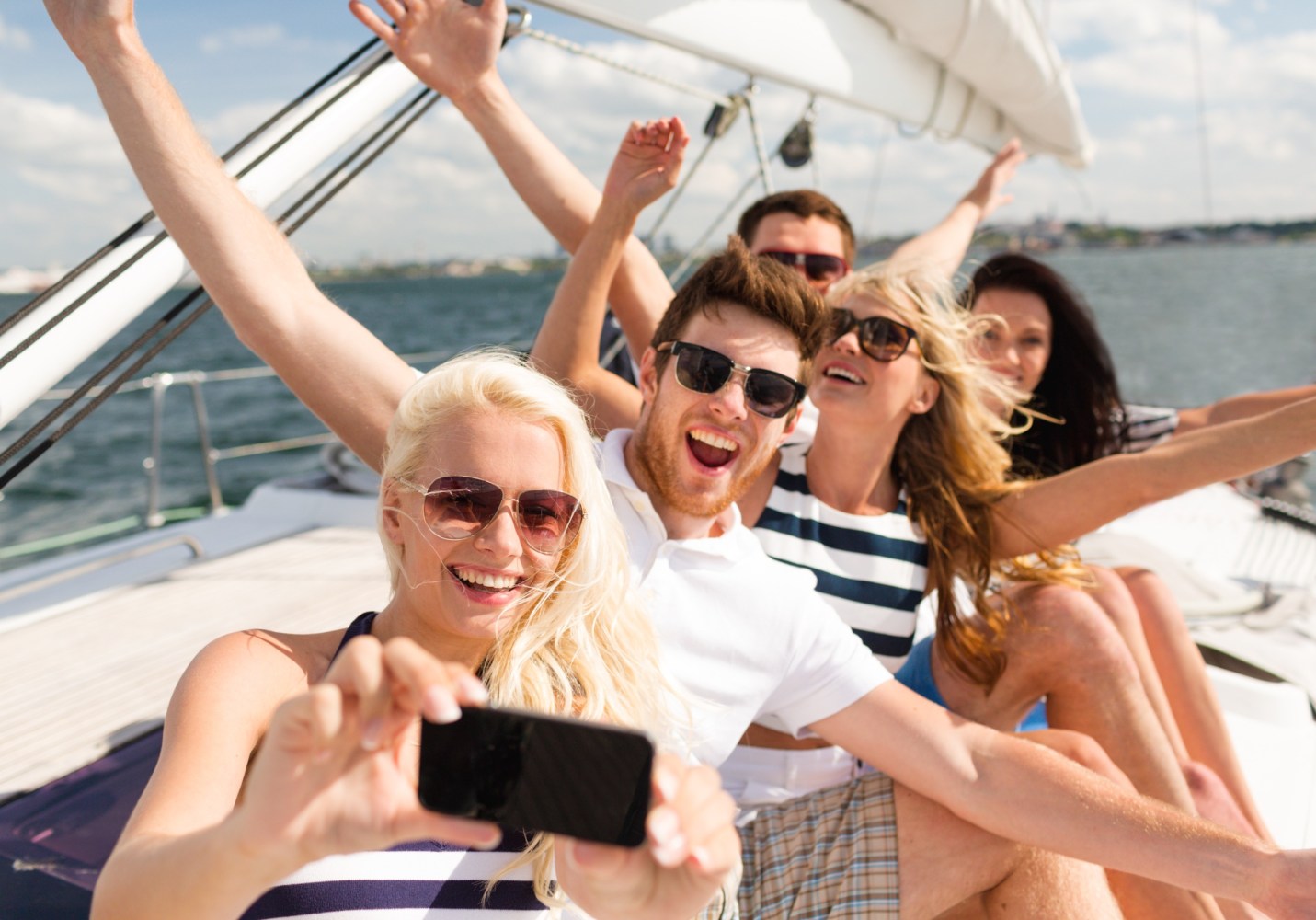 a group of friends on a sailboat taking a selfie photo