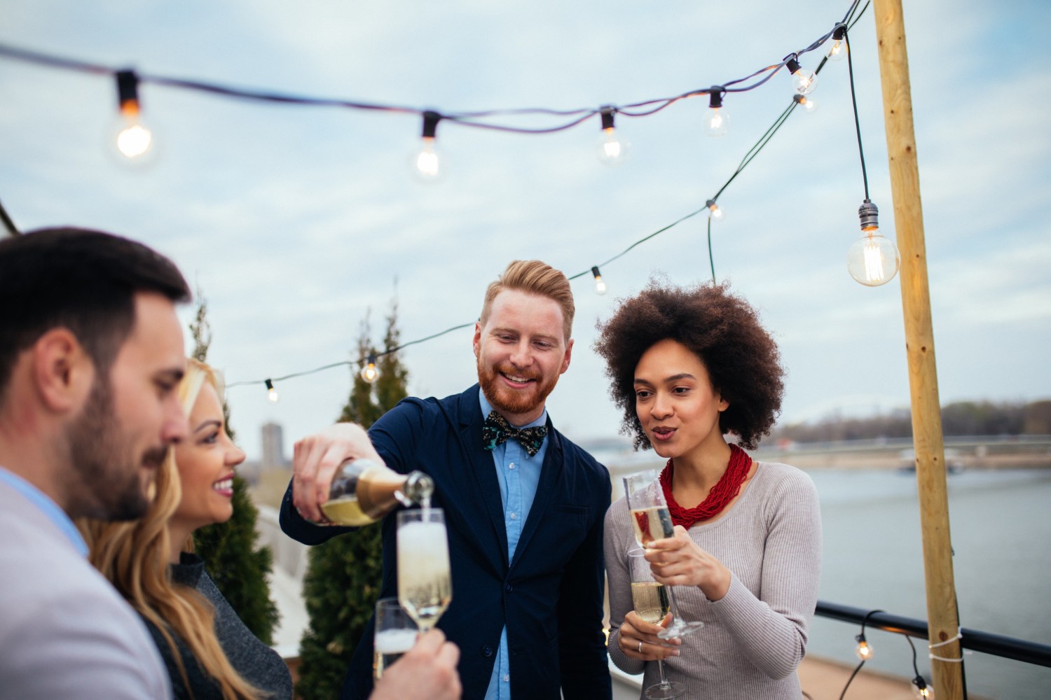 a group of people on a boat pouring and drinking champagne