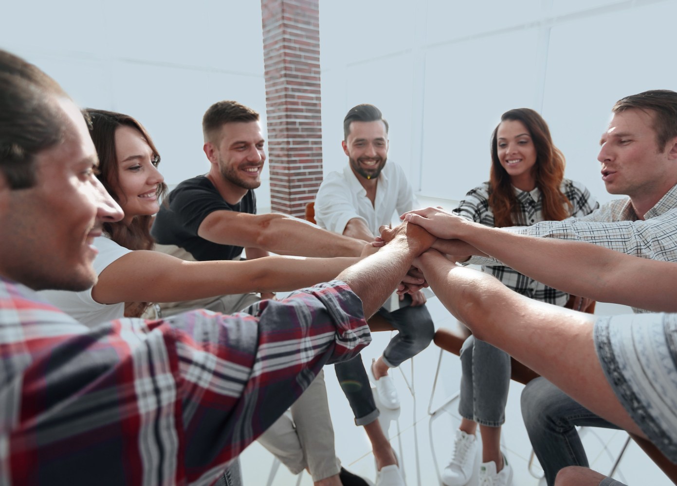 a group of people putting their hands together in teamwork