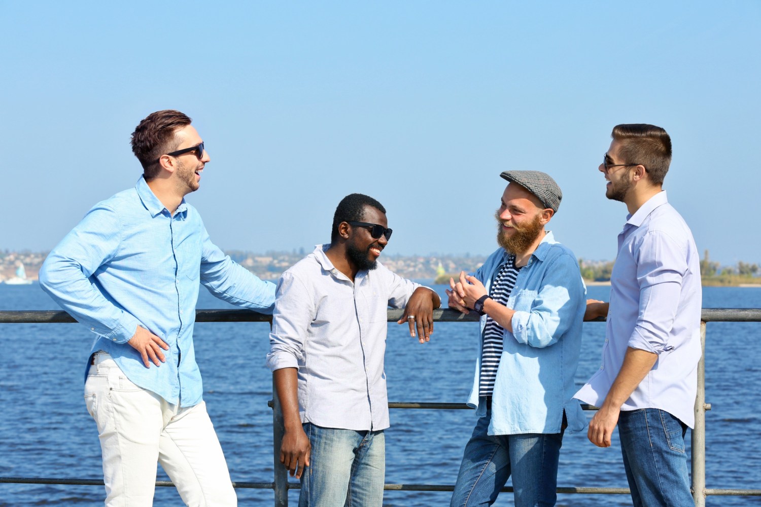 a group of men standing on a pier overlooking the ocean