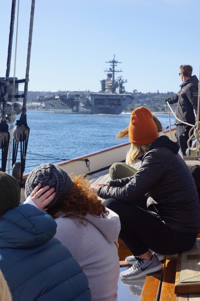 a group of people sitting on a deck of a boat